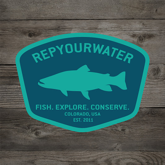 A badge shape sticker in teal and blue with a fish silhouette, repyourwater, fish explore conserve, colorado USA est. 2011