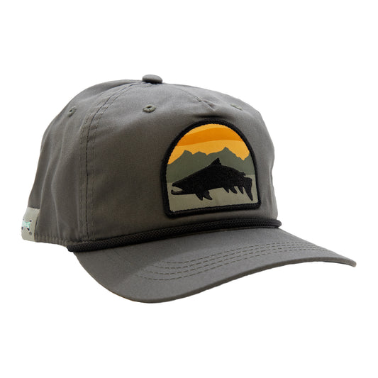 A gray hat with a brim has a patch with a trout in front of a mountain and suns et scene