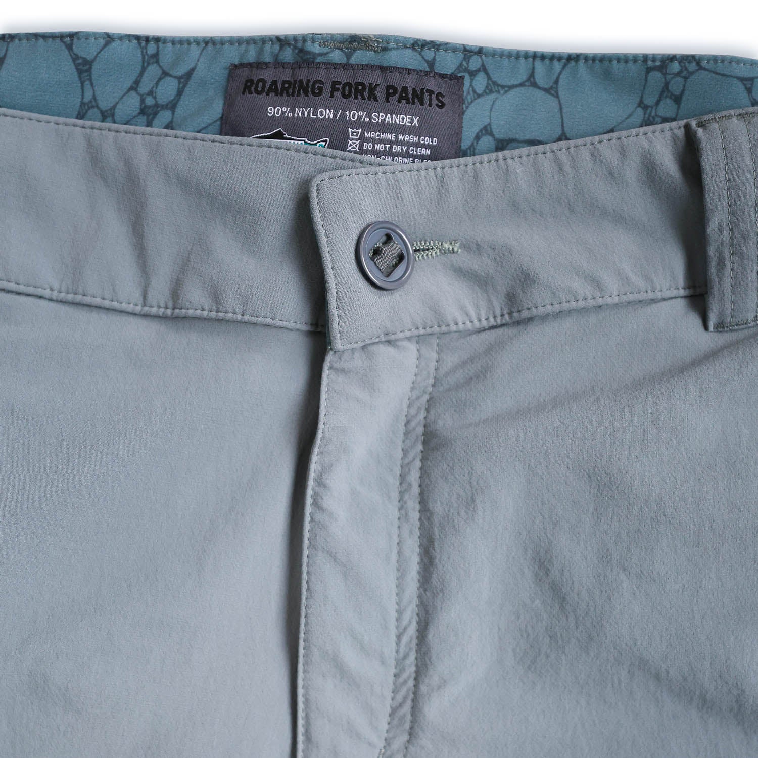 Close-up of light bluepants with a brand label on a white background