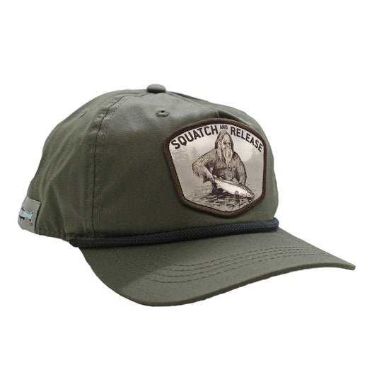 A green hat with a black rope featuring a design showing sasquatch releasing a fish that says squatch and release.
