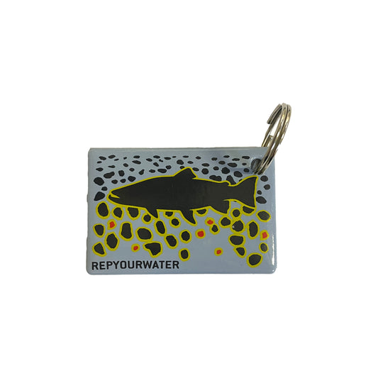 a rectangular key ring has a black trout on top of a brown trout skin inspired design