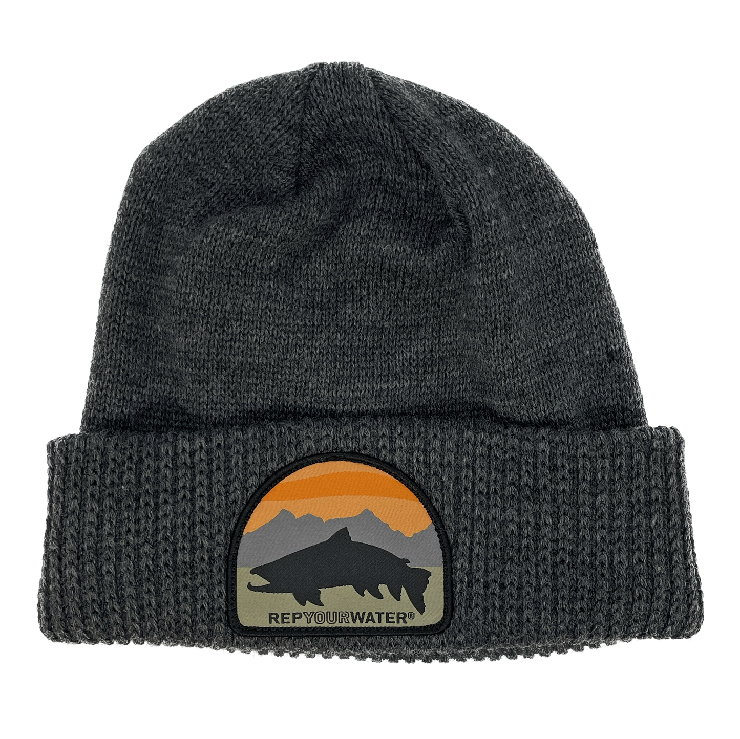A gray winter hat with a cuff and a patch on the cuff with a mountain range background with a black trout silhouette