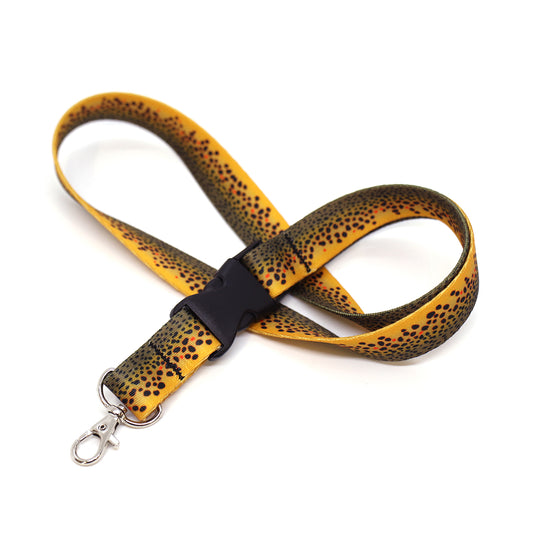 A nylon neck lanyard with a print of brown trout skin and a plastic buckle and a metal clip on the end