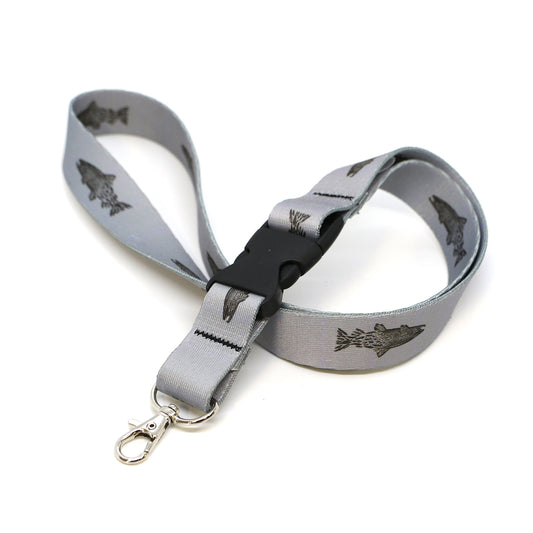 gray lanyard with black buckles and metal clasp that has repeated pattern of a brown trout transitioning into flies towards the tail
