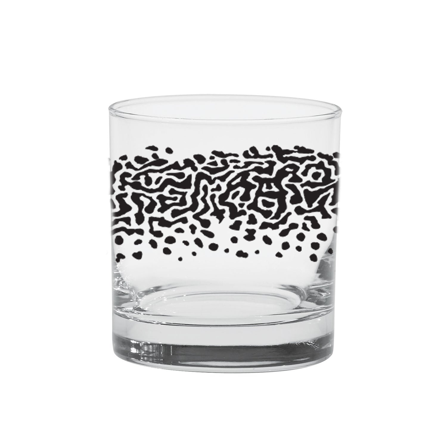 A lowball cocktail glass with black print in the pattern of abbrook trouts back on it