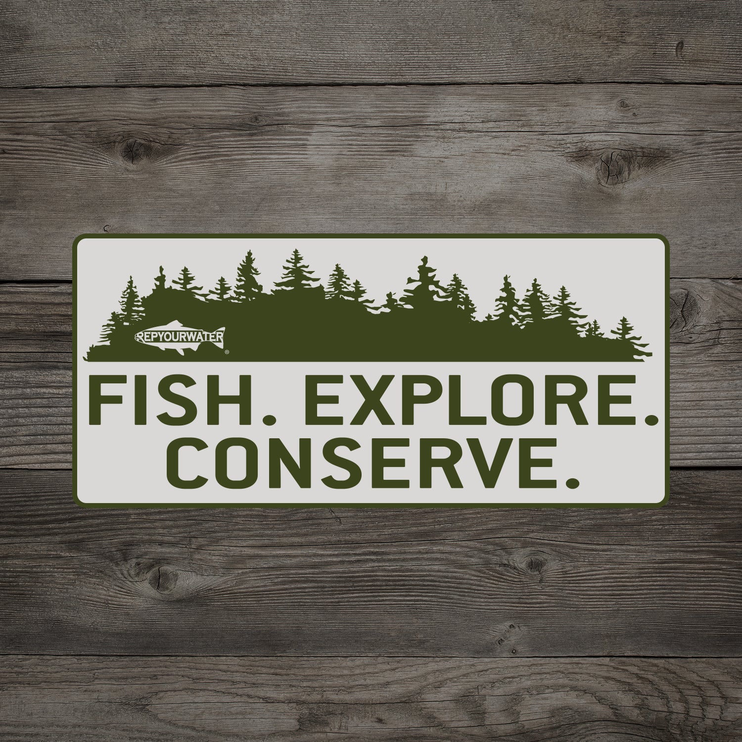 A wooden background has a mockup of a sticker on it which has pine trees above the words fish explore conserve. In the pine trees is a logo that reads repyourwater inside a trout silhouette
