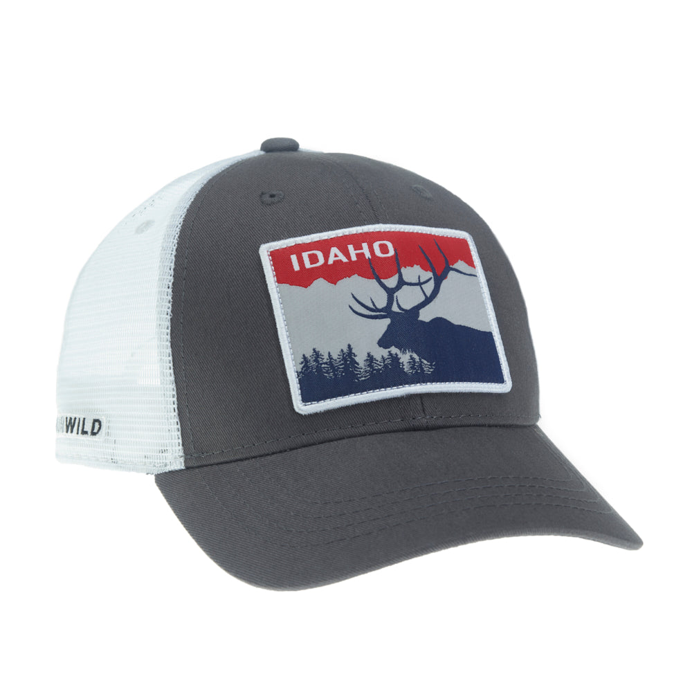 A hat with white mesh in the back, dark gray fabric in the front and a large patch on the front that says "IDAHO" on it as well as the image of an elk, pine trees and mountains.