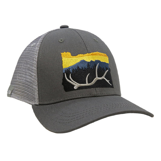 A hat with gray in back and dark gray fabric in front has embroidery in the shape of oregon state with an elk antler in front of trees mountains and a sunset