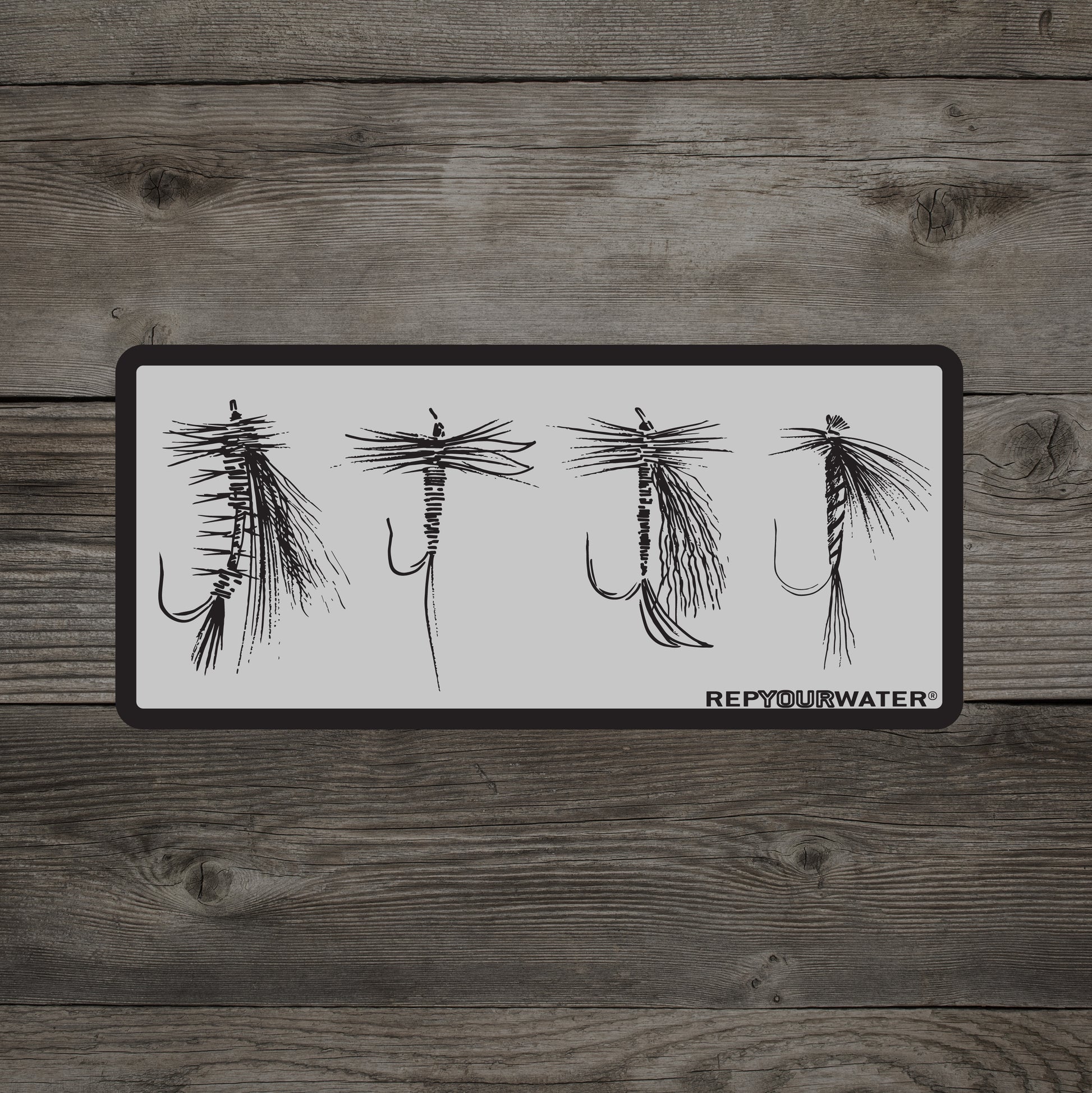 A wooden background has a sticker that shows four dry flies and the words repyourwater