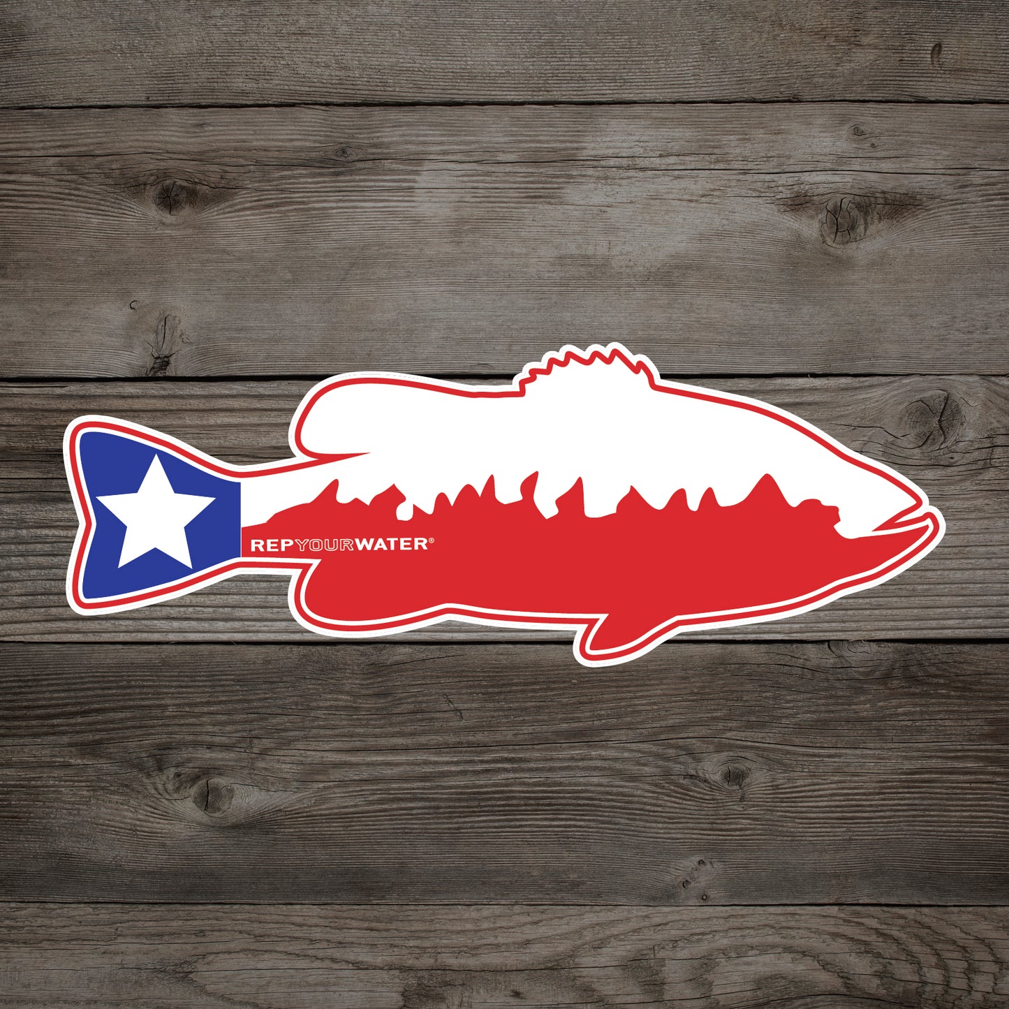A sticker on a wood background features a bass in the colors and design of the texas flag
