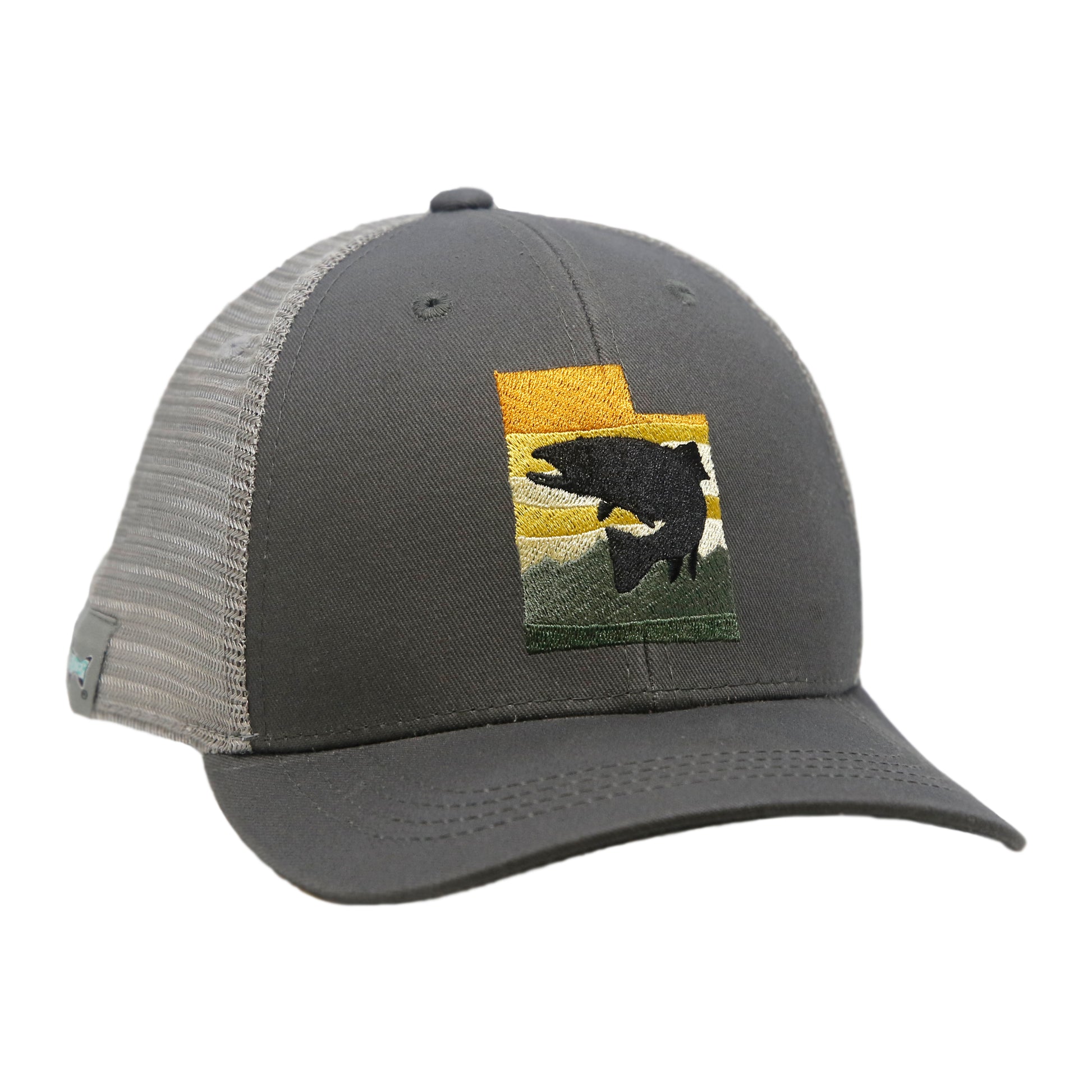 A hat with gray mesh and gray fabric has a design in the shape of utah with trout in front of a mountain and sunset
