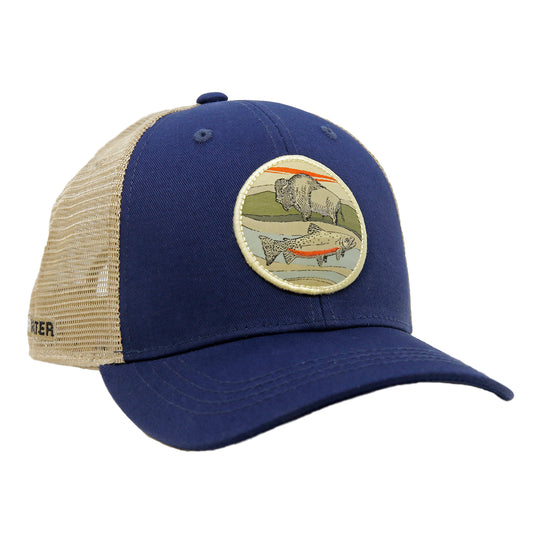 A hat with tan mesh and navy fabric has a patch featuring a bison on a curved line and a trout below the curved line all within a circle